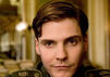 Daniel Brühl schaut bei einem Film in die Kamera und hat eine alte Uniform an