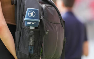 Mikrofon mit ARD-Logo in einem Rucksack