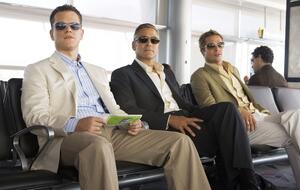 Matt Damon, George Clooney und Brad Pitt sitzen in "Ocean's 13" am Flughafen und blicken in die Ferne