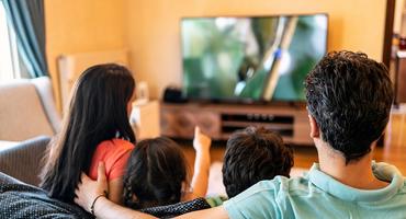 Eine Familie schaut eine Serie auf einem LCD-Fernseher.