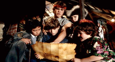 Die Goonies schauen sich eine geheimnisvolle Schatzkarte an.