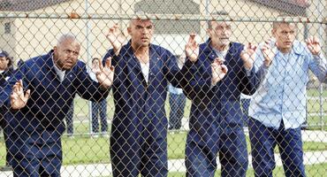 Die Figuren aus "Prison Break" Staffel 1 stehen an einem Machendrahtzaun