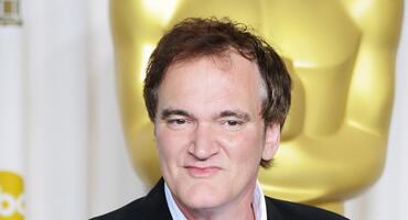 Quentin Tarantino ist bei einem Gala-Auftritt auf dem roten Teppich mit einem Oscar zu sehen