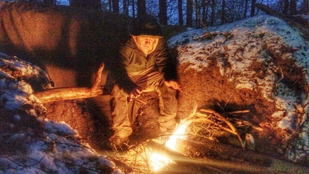 Stefan Hinkelmann am Lagerfeuer im Wald.