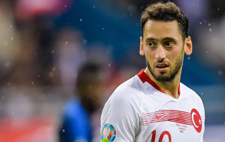 Fußballspieler Hakan Çalhanoğlu steht im weiß-roten Trikot der türkischen Nationalmannschaft auf dem Spielfeld