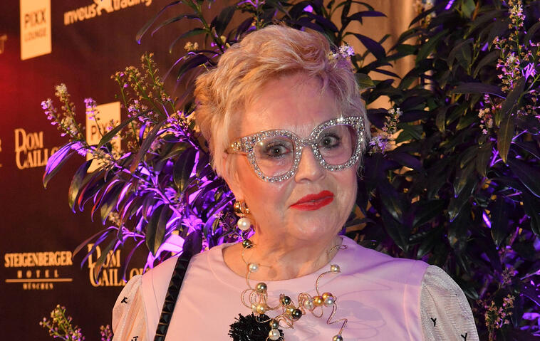 Maritta Emser posiert in weißem Kleid und Glitzerbrille