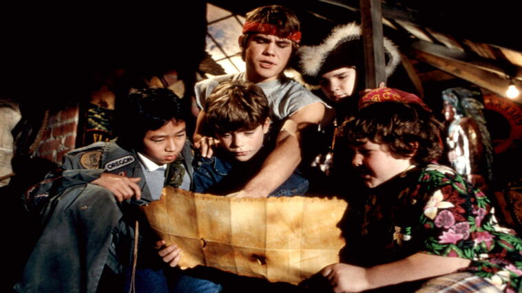 Die Goonies schauen sich eine geheimnisvolle Schatzkarte an.